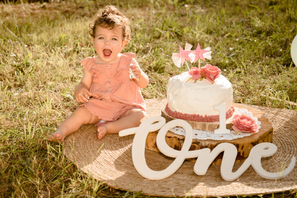 Bambina con torta del primo compleanno